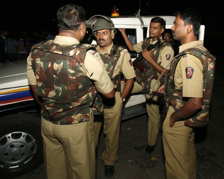 Mumbai anti crime branch officers hold a discussion near the Taj Hotel in Mumbai November 28, 2008. Indian commandos fought room to room battles to save people trapped inside two luxury hotels after coordinated attacks by gunmen across Mumbai that the prime minister blamed on a militant group outside the country. 