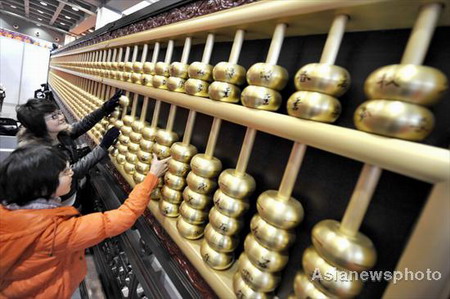 An 11-meter-long bronze abacus made by staff at a 130-year-old famous workshop in Hangzhou, capital city of East China's Zhejiang province, is displayed at a time-honored Chinese brands fair in Hangzhou November 28, 2008. The annual fair aims to explain to visitors the history and present conditions and future development of these traditional Chinese shops and enterprises. [Asianewsphoto] 