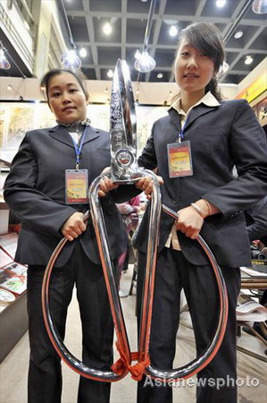 A giant pair of 25-kilogram scissors from Zhang Xiaoquan Shop, a famous traditional Chinese brand, is shown at a time-honored Chinese brands fair in Hangzhou, capital city of East China's Zhejiang province, November 28, 2008. The annual fair aims to explain to visitors the history and present conditions and future development of these traditional Chinese shops and enterprises. [Asianewsphoto]