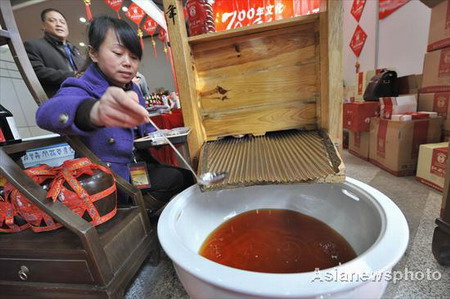  A worker from a famous traditional Chinese wine brand shows the traditional brewing process that is 700 years old at a time-honored Chinese brands fair in Hangzhou, capital city of East China's Zhejiang province, November 28, 2008. The annual fair aims to explain to visitors the history and present conditions and future development of these old Chinese shops and enterprises. [Asianewsphoto] 