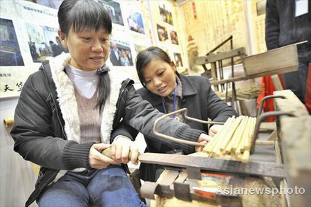 A staff member from a time-honored brand chopstick shop demonstrates how chopsticks are made at a time-honored Chinese brands fair in Hangzhou, capital city of East China's Zhejiang province, November 28, 2008. The annual fair aims to explain to visitors the history and present conditions and future development of these old Chinese shops and enterprises. [Asianewsphoto] 