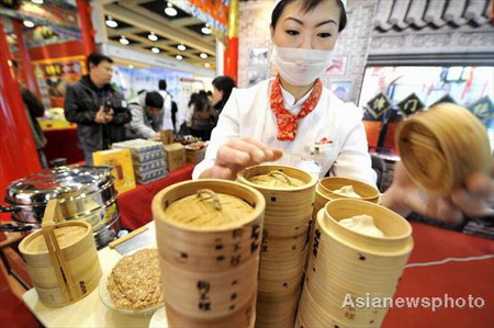 A chef from the Goubuli enterprise, a famous traditional Chinese brand in Tianjin Municipality, shows off new types of xiaolongbao, a Chinese steamed dumpling, at a time-honored Chinese brands fair in Hangzhou, capital city of East China's Zhejiang province, November 28, 2008. The annual fair aims to explain to visitors the history and present conditions and future development of these old Chinese shops and enterprises. [Asianewsphoto]