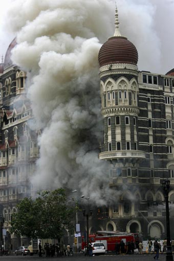  Taj Mahal hotel is seen engulfed in smoke during a gun battle in Mumbai November 29, 2008. Operations by Indian commandos to dislodge Islamist militants at Mumbai's Taj Mahal hotel ended on Saturday, Indian television channels quoted officials as saying. The hotel came under heavy gunfire and flames leaped out of the building shortly before the announcement. [Agencies]