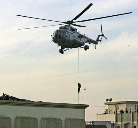 A National Security Guard (NSG) commando rappels from a helicopter near Nariman House where suspected militants are believed to be hiding, in Mumbai November 28, 2008. Indian commandos stormed a Jewish centre in Mumbai on Friday evening, killing two Islamist gunmen but failing to save five hostages, after two days of bloodshed that have created fresh tensions with old foe Pakistan. [Agencies]