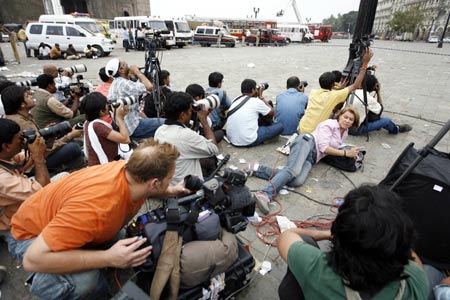 Photographers and members of the media cover a gunfire at the Taj Hotel in Mumbai November 28, 2008. [Agencies]