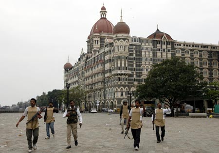 Members of anti-terror squad remove members of the media from the area in front of the Taj Hotel in Mumbai November 28, 2008. [Agencies]