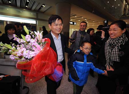 Huang Zhong(2nd,L) , a Chinese civilian back from Thailand, arrives at the Capital International Airport in Beijing, capital of China, on Nov. 30, 2008. The first charter plane from Air China Airlines boarded passengers who were stranded in Thailand, back to Beijing at 5:40 AM on Sunday. [Luo Xiaoguang/Xinhua]