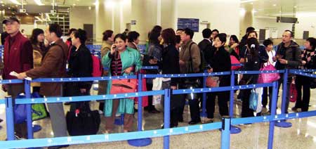 Chinese tourists, once stranded after the closure of airports in Bangkok, arrive at Shanghai Pudong International Airport, in Shanghai, on Nov. 29, 2008. The 46 tourists returned to Shanghai on Saturday aboard a Dragonair flight. They had to drive to Phuket island, more than 1,000 km south of Bangkok, to be flown to Hong Kong and then the Chinese mainland.[Xinhua Photo] 