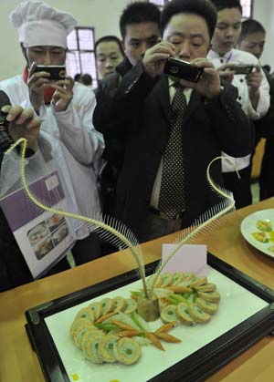 Visitors take photos of a dish during the 6th National Cooking Contest (Hubei Zone) held in Wuhan, capital of central China's Hubei Province, Nov. 29, 2008.[Zhou Chao/Xinhua]
