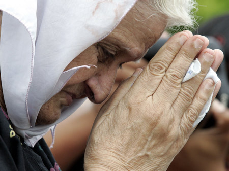 An elderly woman prays for victims of the Mumbai attacks in front of Taj Mahal Hotel in Mumbai Nov. 30, 2008. [Xinhua/Reuters]