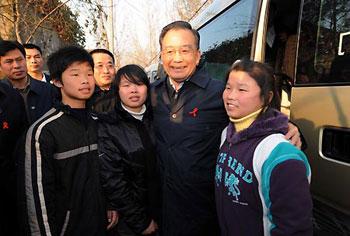 Chinese Premier Wen Jiabao (C) hugs three kids, whose parents passed away due to HIV/AIDS, in Fuyang prefecture, east China's Anhui Province, Nov. 29, 2008. Wen visited people living with HIV/AIDS and workers dealing with the disease in Fuyang over the weekend, prior to the World AIDS Day which falls on December 1. [Rao Aimin/Xinhua] 