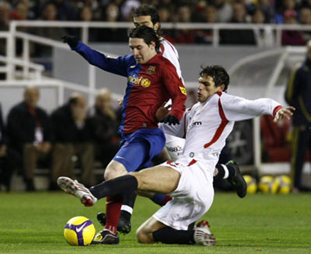 Barcelona's Lionel Messi (L) is challenged by Sevilla's Federico Fazio during their Spanish First Division soccer match at Ramon Sanchez Pizjuan stadium in Seville Nov. 29, 2008.