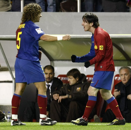 Barcelona's Leo Messi (R) celebrates with Carles Puyol after scoring against Sevilla during their Spanish First Division soccer match at Ramon Sanchez Pizjuan stadium in Seville Nov. 29, 2008. 