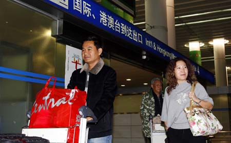 Passengers walk out from the terminal of the Shanghai Pudong International Airport in Shanghai, east China, on Nov. 30, 2008. 