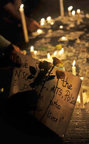 People light candles during a vigil for terror attack victims in Mumbai, India, Nov. 30, 2008. India's longest terror nightmare that lasted for almost 59 hours ended Saturday. Mumbai disaster authorities put the death toll to 195 and the injured 295.[Liu Sui Wai/Xinhua]