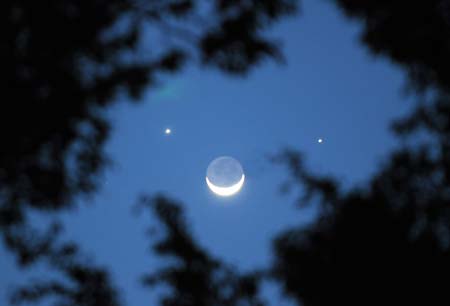 A crescent moon is seen below planets Jupiter (L) and Venus (R) in the sky over Nairobi, capital of Kenya, Dec. 1, 2008. A rare astronomical phenomenon was seen across the world Monday night as two of the brightest naked-eye planets, Venus and Jupiter, joined a thin crescent moon in the sky. On Sunday night, the two planets appeared closest together in an event known as 'Planetary Conjunction'. [Xu Suhui/Xinhua]