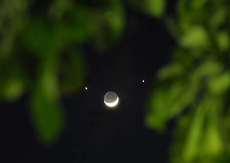 A crescent moon is seen below planets Jupiter (L) and Venus (R) in the sky over Nairobi, capital of Kenya, Dec. 1, 2008. A rare astronomical phenomenon was seen across the world Monday night as two of the brightest naked-eye planets, Venus and Jupiter, joined a thin crescent moon in the sky. On Sunday night, the two planets appeared closest together in an event known as 'Planetary Conjunction'. [Xu Suhui/Xinhua]