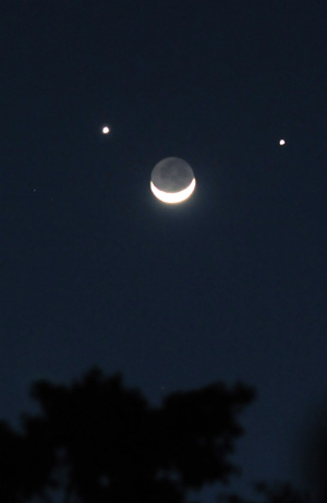 A crescent moon is seen below planets Jupiter (L) and Venus (R) in the sky over Nairobi, capital of Kenya, Dec. 1, 2008. A rare astronomical phenomenon was seen across the world Monday night as two of the brightest naked-eye planets, Venus and Jupiter, joined a thin crescent moon in the sky. On Sunday night, the two planets appeared closest together in an event known as 'Planetary Conjunction'.[Xu Suhui/Xinhua]