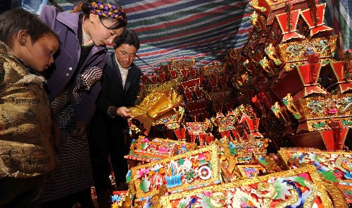 Tenzin Wangmu (M), farmer from Comai County of Lhoka Prefecture, is buying chemar (a box containing Tsampa) with her family members, Dec. 1.[eng.tibet.cn] 