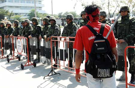 A protestor walks in front of the Bangkok Intermediate Administrative Court during a rally held by government supporters to protest against Thai Constitution Court's order to dissolve the three ruling parties in Bangkok Dec. 2, 2008.[Xinhua] 