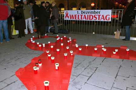 People put candles on the red ribbon during a parade calling for AIDS prevention in Vienna, Austria, on Dec. 1, 2008. Hundreds of people attended the candle parade for the World AIDS Day on Dec. 1 in Vienna. [Xinhua]