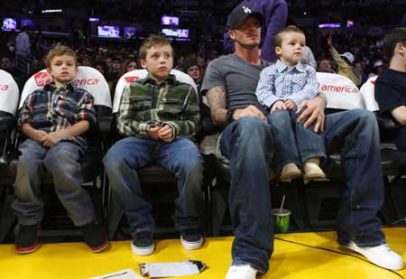 Soccer star David Beckham watches the Los Angeles Lakers play the Toronto Raptors in their NBA basketball game with his sons (L-R) Romeo, Brooklyn and Cruz in Los Angeles Nov. 30, 2008. 
