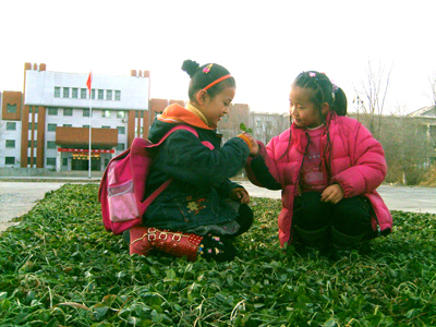 Two girls play in a grassland of Xinhu Farmland in northwest China's Xinjiang Uygur Autonomous Region on November 30, 2008. Prolonged periods of drought resulting from China's 23rd consecutive 'warm winter' will pose a serious threat to the country's crop yields, the China Meteorological Administration (CMA) said in a report published Tuesday.