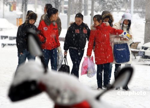 Young people go shopping through the snow in Urumchi, capital of northwestern China's Xinjiang Uygur Autonomous Region on Tuesday, December 3rd, 2008. [Photo: cnsphoto]