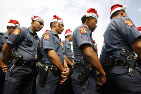 Members of the Philippine National Police wear Santa Claus hats during the launch of the 'Santa Cop 2008' initiative outside a mall in Manila Dec. 2, 2008. Around 200 policemen wearing Santa Claus hats will be deployed from Tuesday in malls and other crowded areas to enhance the visibility of their patrols and crime prevention efforts during the holiday season, a police officer said. [Xinhua/Reuters]