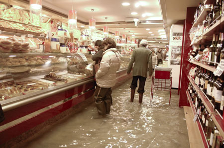 Customers stand in flood waters in a pastry shop in Venice December 1, 2008. Large parts of Venice were flooded on Monday as heavy rains and strong winds lashed the lagoon city, with sea levels at their highest level in 22 years. [China Daily via Agencies] 
