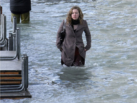 A woman wades through flood waters in Venice December 1, 2008. Large parts of Venice were flooded on Monday as heavy rains and strong winds lashed the lagoon city, with sea levels at their highest level in 22 years. [China Daily via Agencies] 