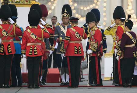 Royal guards men salute Thailand's revered King Bhumibol Adulyadej (3rd R) as he arrives to attend the Trooping of the Colour, an annual military parade, in Bangkok's Royal Plaza on Dec. 2, 2008. [Xinhua/Reuters]