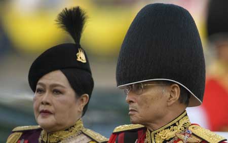 Thailand's revered King Bhumibol Adulyadej (R) and Queen Sirikit attend the Trooping of the Colour, an annual military parade, in Bangkok's Royal Plaza on Dec. 2, 2008.[Xinhua/Reuters]