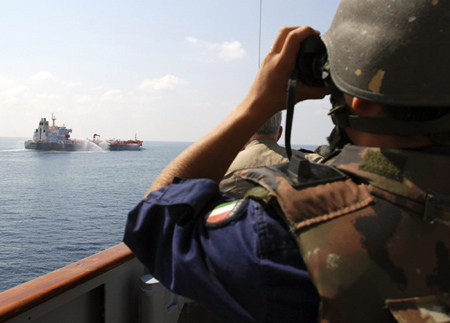 An Italian sailor watches as the Hong Kong flagged merchant ship M/V Overseas Hercules uses fire hoses as a countermeasure against a possible pirate attack in the Gulf of Aden December 2, 2008. According to NATO headquarters in Naples, the Italian naval destroyer ITS Luigi Durand de la Penne arrived following a distress call and instructed the vessel to use its fire hoses to thwart an attack. No attack was made on the ship. [China Daily via Agencies]