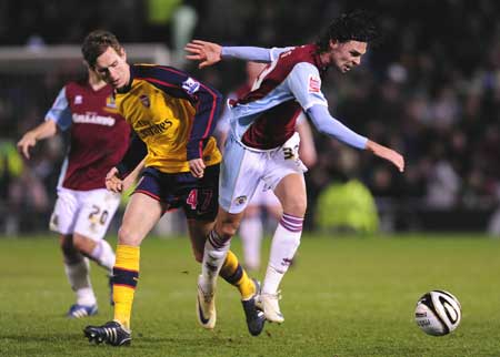 Arsenal's Mark Randall (L) challenges Burnley's Chris Eagles during their English League Cup soccer match in Burnley, northern England Dec. 2, 2008. 