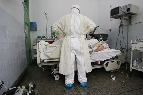 A doctor stands in front of a dead SARS-infected patient on April 30, 2003. The SARS storm changed the ordinary life of people, but the whole nation built a new level of solidarity. 