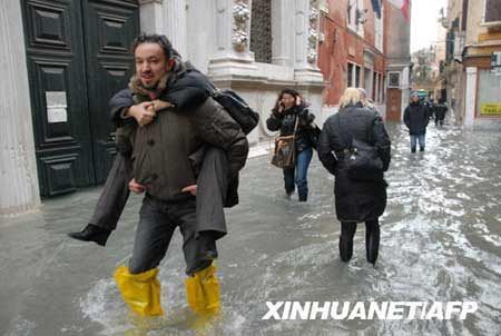 People wade through high water in Venice's St. Mark's Square, northern Italy, Monday, Dec. 1, 2008. 