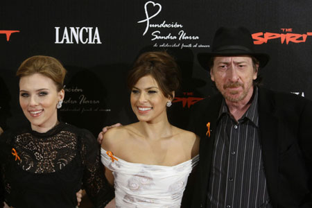 U.S. actresses Scarlett Johansson (L) and Eva Mendes (C) pose with U.S. director Frank Miller during a solidarity cocktail benefit for cancer in Madrid December 2, 2008. 