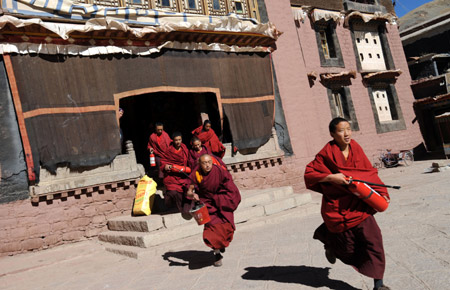 Picture taken on Nov. 28, 2008 shows Tibetan Buddhist monks rush to a fire site during a drilling at Sagya Monastery in Xigaze of southwest China's Tibet Autonomous Region. Some 35 temples and lamaseries in the region have established their own fire brigades comprised of buddhist monk volunteers in recent years. [Xinhua] 