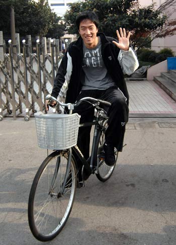 Liu Xiang (C), former 110m hurdle world and Olympic champion, waves to reporters before leaving for the United States for treatment, in Shanghai, east China, Dec. 3, 2008. Liu Xiang, accompanied by his mother and coach, flew to Houston Wednesday to receive treatment of his troublesome right foot. [Xinhua] 