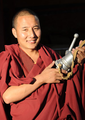 Picture taken on Nov. 29, 2008 shows a Tibetan Buddhist monk hoding a fire hose during a drilling at Zhaxi Lhunbo Lamasery in Xigaze of southwest China's Tibet Autonomous Region. [Xinhua]