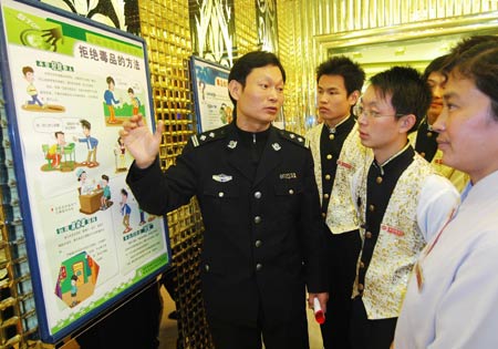 A policeman introduces the harmfulness of drugs to waiters at a KTV store in Chaohu City, east China's Anhui Province, Dec. 2, 2008. Campaigns to publicize laws were launched all over the country in recent days to mark the National Law Publicity Day, which falls on Dec. 4. [Xinhua]