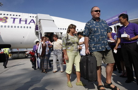 Passengers exit an Thai Airways flight from Phuket, the first to land at Bangkok's Suvarnabhumi Airport December 3, 2008, after a week long anti-government protest paralyzed air travel. 