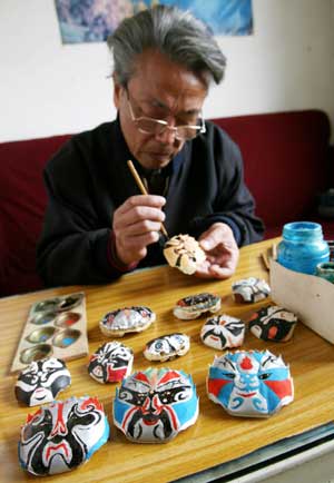  Zhang Shoupei paints on crab shells with traditional local opera facial make-up at Shantang Community in Suzhou, east China's Jiangsu Province, Dec. 3, 2008. Zhang enjoys painting opera facial make-up patterns on crab shells as a hobby. [Xinhua]