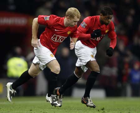 Manchester United's substitutes Paul Scholes (L) and Patrice Evra take to the pitch during their English League Cup soccer match against Blackburn Rovers at Old Trafford in Manchester, northern England, Dec. 3, 2008.[Xinhua/Reuters]