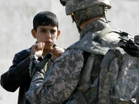 A resident talks to a U.S. soldier guarding a mosque in the Hurriya district northwest of Baghdad December 3, 2008.[Xinhua]