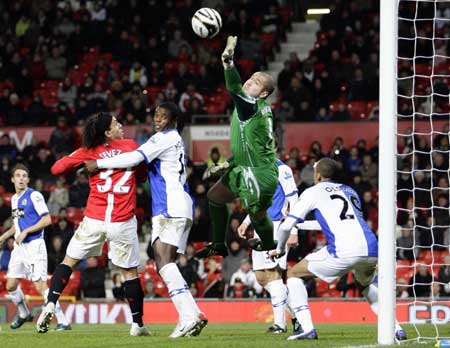 Blackburn Rovers' goalkeeper Paul Robinson (C) saves a header from Manchester United's Carlos Tevez (32) during their English League Cup soccer match at Old Trafford in Manchester, northern England, Dec. 3, 2008. 