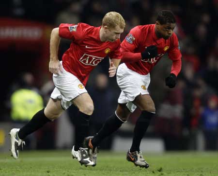 Manchester United's substitutes Paul Scholes (L) and Patrice Evra take to the pitch during their English League Cup soccer match against Blackburn Rovers at Old Trafford in Manchester, northern England, Dec. 3, 2008. 