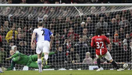 Manchester United's Carlos Tevez (R) scores a penalty past Blackburn Rovers' goalkeeper Paul Robinson (L) during their English League Cup soccer match at Old Trafford in Manchester, northern England, Dec. 3, 2008. 