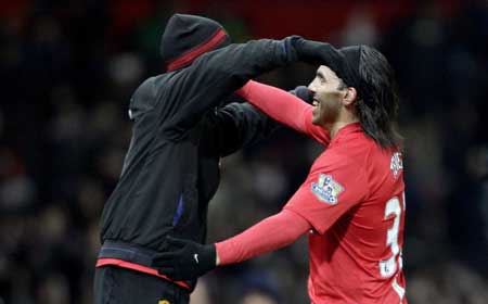 Manchester United's Carlos Tevez (R) celebrates his goal against Blackburn Rovers with Evra during their English League Cup soccer match at Old Trafford in Manchester, northern England, Dec. 3, 2008. 